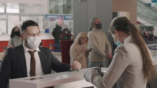 Travelers Wearing Masks at Airport Check-In