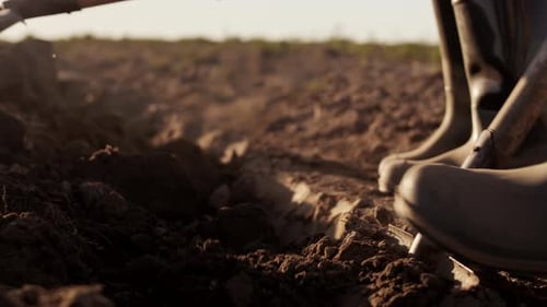 Shovel Digging Dirt in the Field at Sunrise