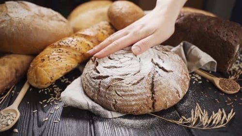Woman Puts Whole Homemade Bread on Wooden Table, Slow Motion.