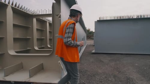Construction Supervisor Walking Through New Concrete Structures