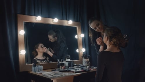 Makeup Artist Applying Makeup to Woman at Vanity