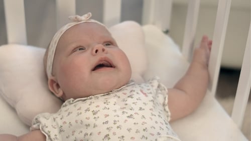 Loving Care for Adorable Infant in Crib