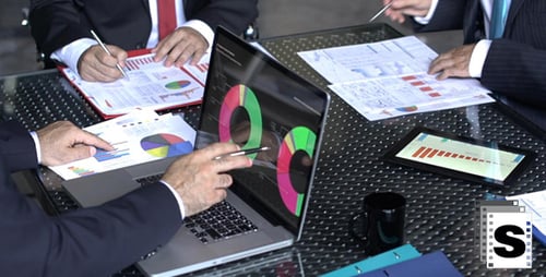 Businessmen Analyzing Charts at Corporate Meeting