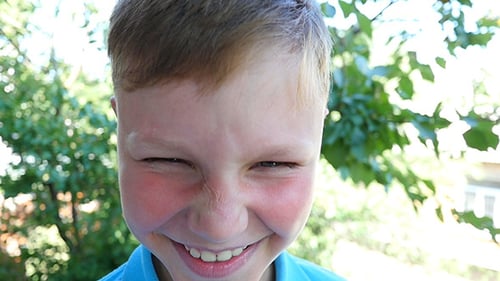 Smiling Child's Face Close Up in Nature