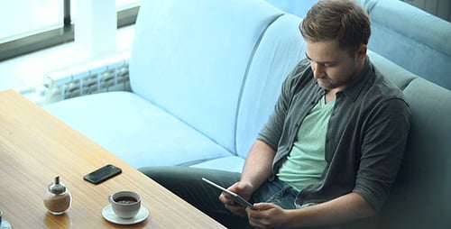 Young Adult Using Tablet in Cafe