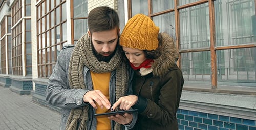 Tourists Using Tablet for Navigation on City Street