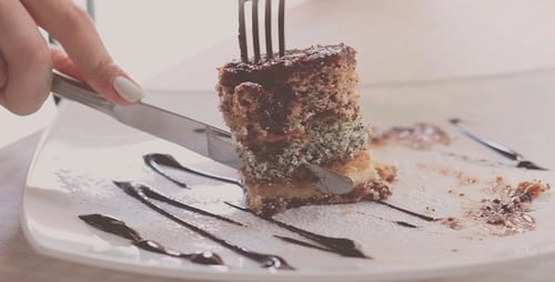 Slicing a Delicious Layered Cake with Chocolate Garnish