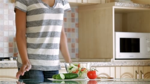 Woman Eats Salad in Bright Kitchen