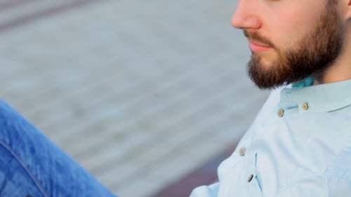 Handsome Man Sitting Outdoors With His Phone