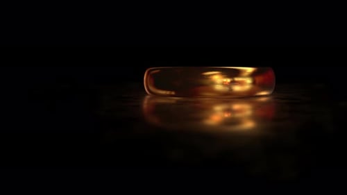 Voler autour de la bague en or LE SEIGNEUR DES ANNEAUX sur la surface en verre mat