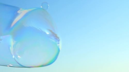 Iridescent Soap Bubbles Gently Floating on Blue Sky