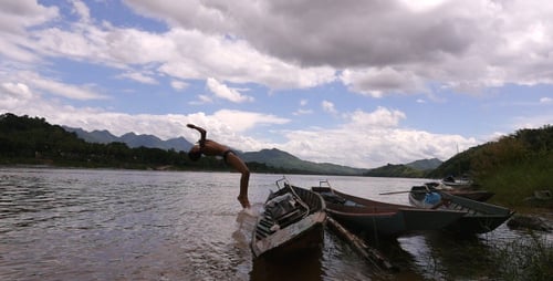 Young Person Doing Backflip off Boat into River