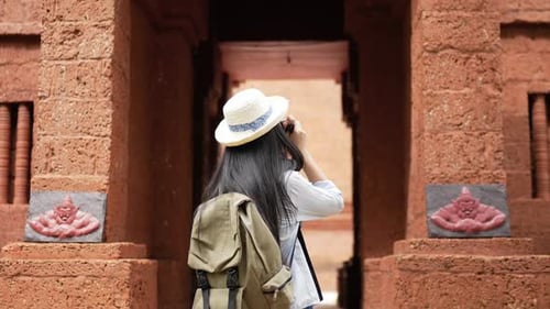 Woman visiting and taking a photo ancient temple