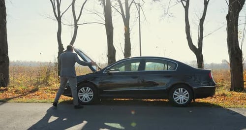 Desperate Businessman Standing and Speak on Phone Near the Broken Car Opened the Hood Road Help