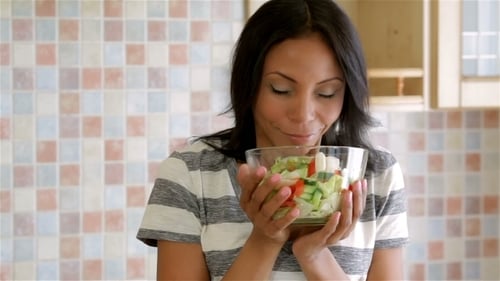Woman Enjoys Fresh Salad in Kitchen