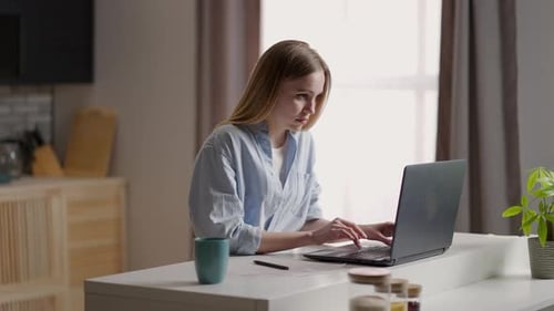 Woman Working on Laptop Computer at Table