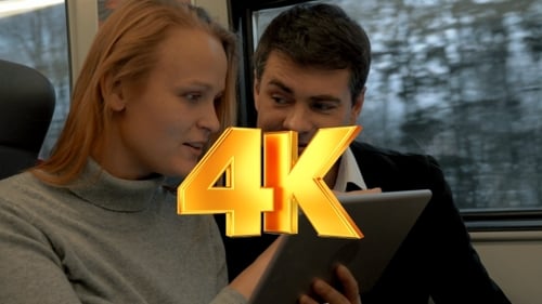 Adults Use Tablet Together on a Moving Train