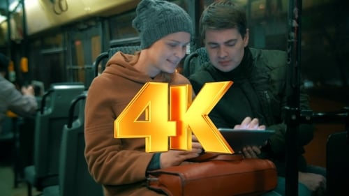 Woman Using Tablet With Friend On Night Bus