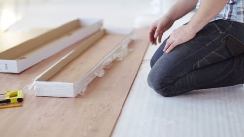 Man With Measuring Tape And Wood Flooring At Home
