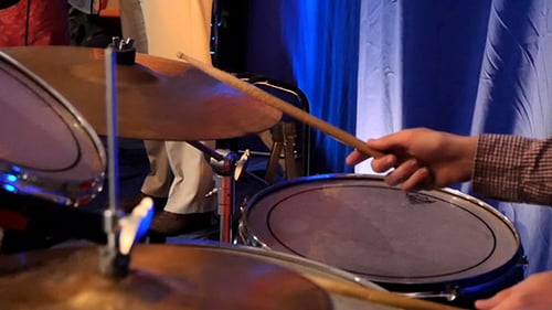 Baterista tocando percusión en concierto de rock