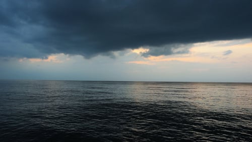Dramatic Clouds over Peaceful Ocean at Sunset