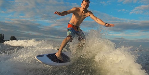 Man Wake Surfing on a Sunny Lake