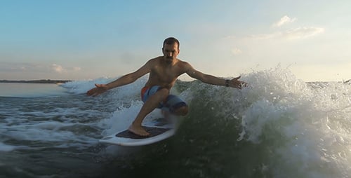 Man Wakeboarding on a Wave on a Sunny Day