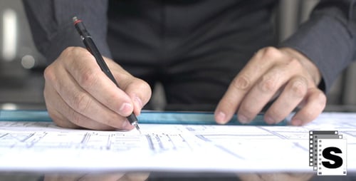 Architect Drawing on Blueprint Using Pen and Ruler