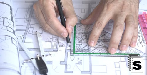 Hands Draw Architectural Plans with Pencil and Ruler