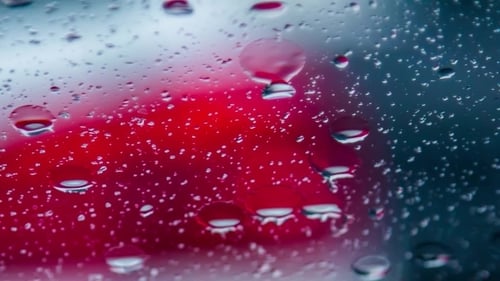 Regentropfen laufen bei Regen auf Autofenster