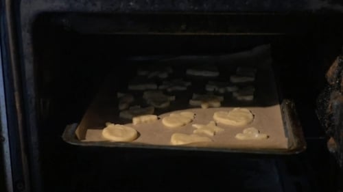 Putting Baking Tray With Cookies Into The Oven