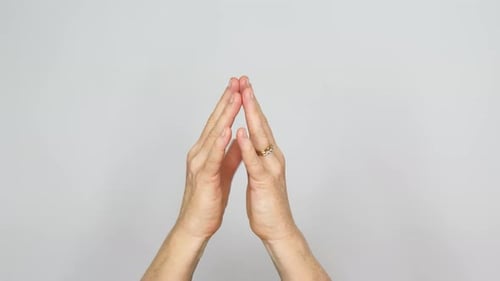 Kontemplative Geste der Fingerspitzen, die ihre Spitzen rhythmisch zusammenklopfen.