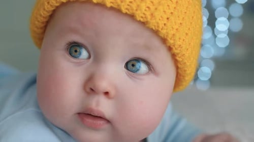 Adorable Baby with Blue Eyes Wearing a Yellow Hat