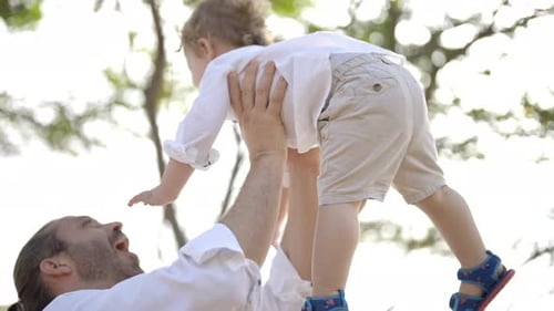 4K Caucasian father carrying and playing with little baby son on tropical beach in sunny day.
