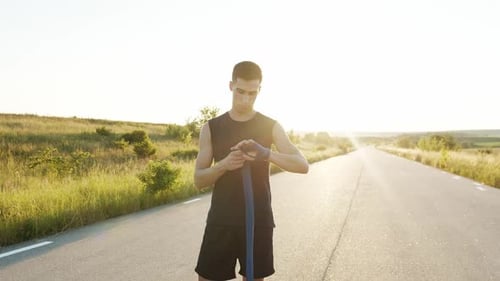 Athletic Man Wraps His Wrist Brace Outdoors