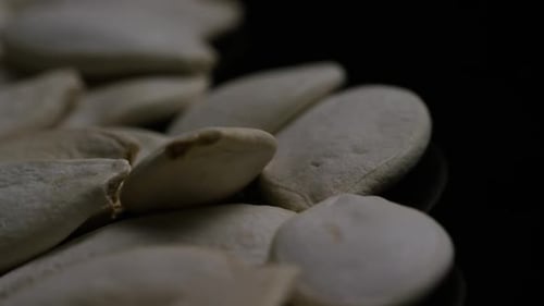 Pile of Pumpkin Seeds Rotating on Black Background