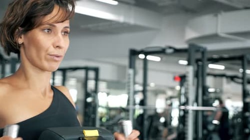 Portrait of Woman is Making Exercises for Spine Muscles on Rowing Machine
