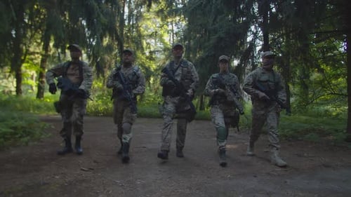 Gruppe von Militärs, die im Morgengrauen in einer Reihe auf die Kamera zugehen