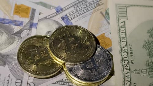 Bitcoin BTC Coin e Ethereum ETH Coins girando em notas em dinheiro de 100 dólares Mineração virtual de dinheiro