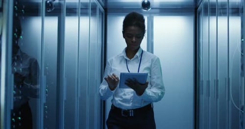 Data Technician with Tablet Inspecting Data Servers