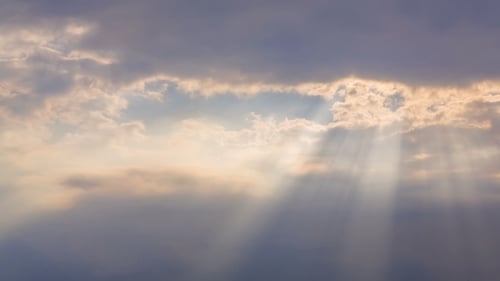 Golden Sunlight Rays Streaming Through Dramatic Clouds