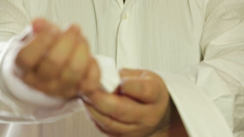 Man Buttoning Sleeves Of The Shirt