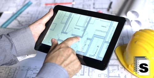 Architect Using Tablet with Blueprints and Plans