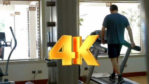 Man Walking on Treadmill in Bright Gym