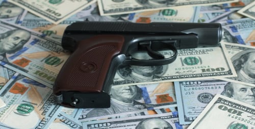 Billetes de cien dólares y un arma