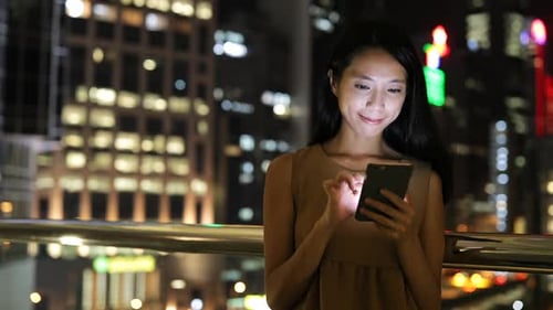 Woman Using Smartphone in City at Night