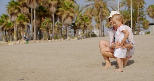 Mom And Daughter At The Beach On a Very Sunny Day