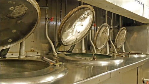 Large Shiny Industrial Cooking Pots in Kitchen