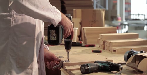 Worker Assembling Wood Piece with Power Drill
