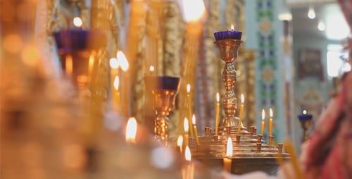 Woman Lights Candles in Church